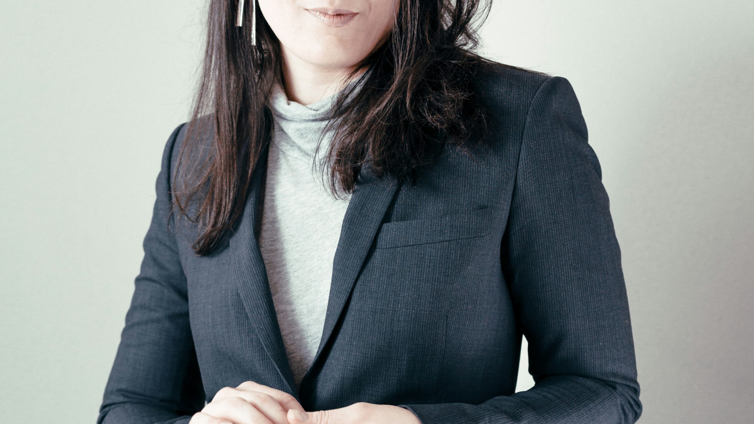 woman in gray turtleneck sweater and gray blazer